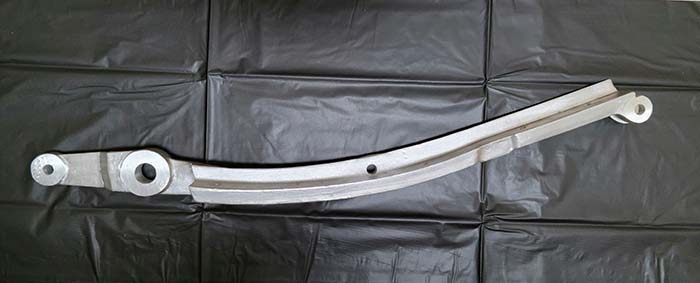 Raw aluminum forward rail casting on a white background