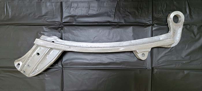 Raw aluminum rail casting on a white background